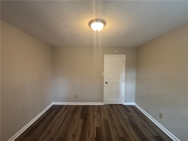 unfurnished room featuring dark hardwood / wood-style floors and a textured ceiling