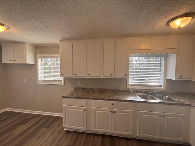 kitchen featuring white cabinetry, sink, dark wood-type flooring, and a textured ceiling