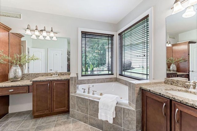 bathroom featuring tile patterned floors, tiled bath, and vanity