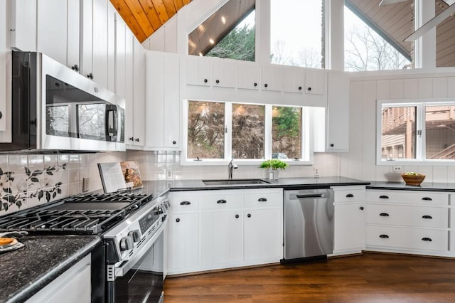 kitchen featuring a sink, dark countertops, backsplash, and stainless steel appliances