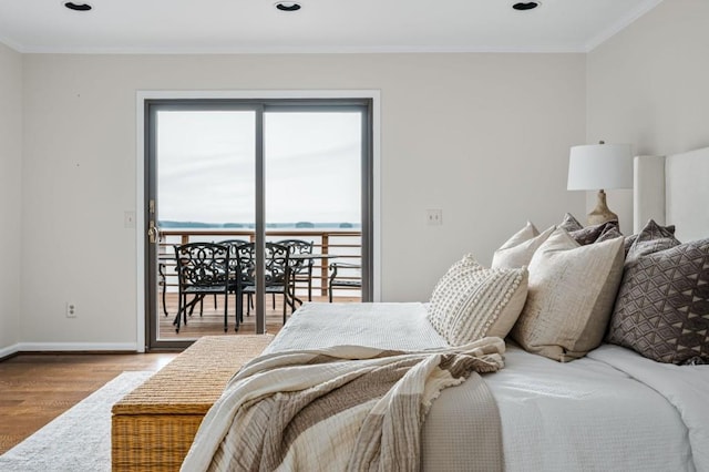 bedroom with access to exterior, crown molding, baseboards, and wood finished floors