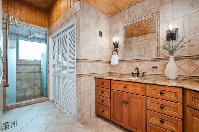 bathroom featuring tile walls, visible vents, a stall shower, vanity, and tile patterned floors