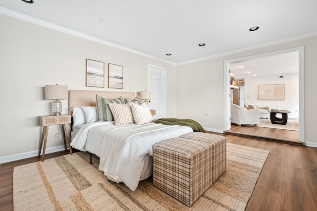 bedroom featuring recessed lighting, wood finished floors, baseboards, and ornamental molding