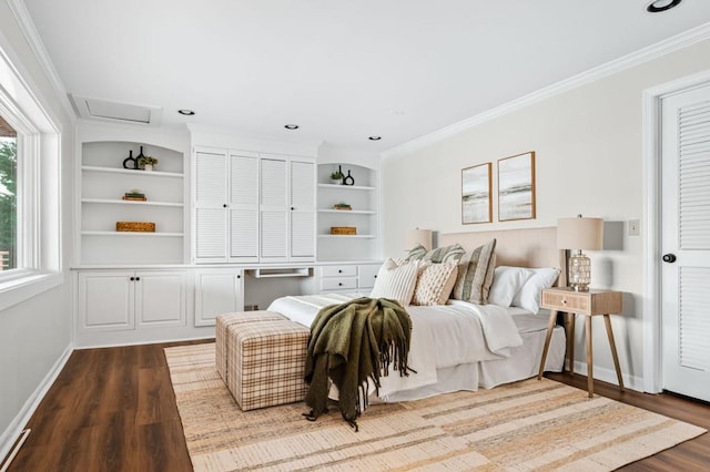 bedroom with baseboards, wood finished floors, attic access, and crown molding