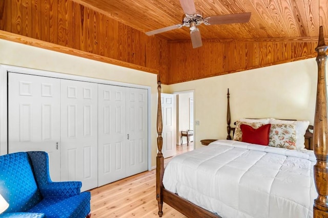 bedroom with vaulted ceiling, a closet, light wood-type flooring, and wood ceiling