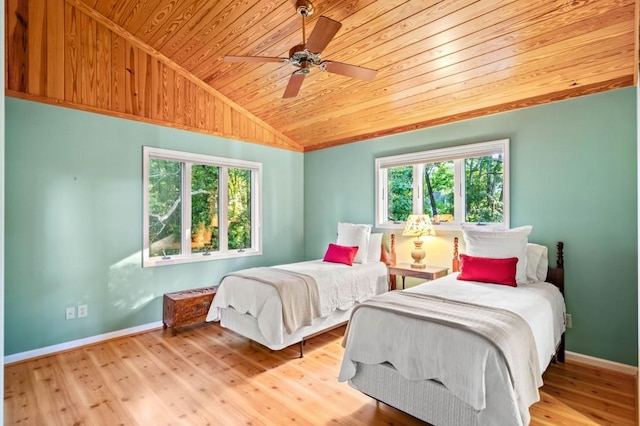 bedroom with vaulted ceiling, wood ceiling, baseboards, and wood finished floors