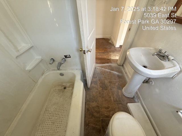 full bath featuring a tub, a sink, and toilet