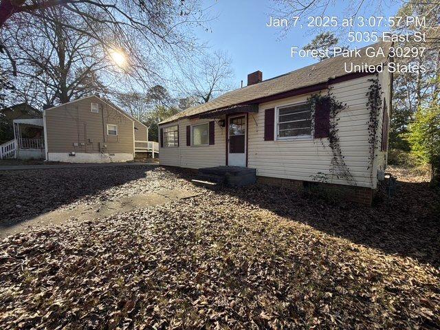 back of house featuring crawl space and a chimney