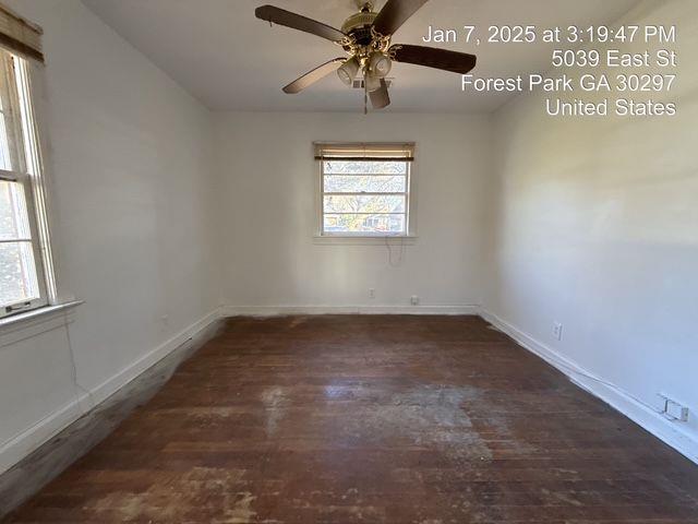 unfurnished room with ceiling fan, wood finished floors, and baseboards