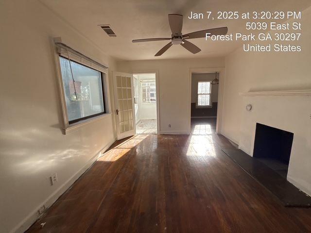interior space featuring a ceiling fan, baseboards, visible vents, and hardwood / wood-style floors