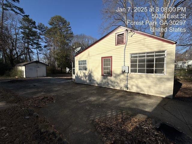 view of side of property featuring a shed