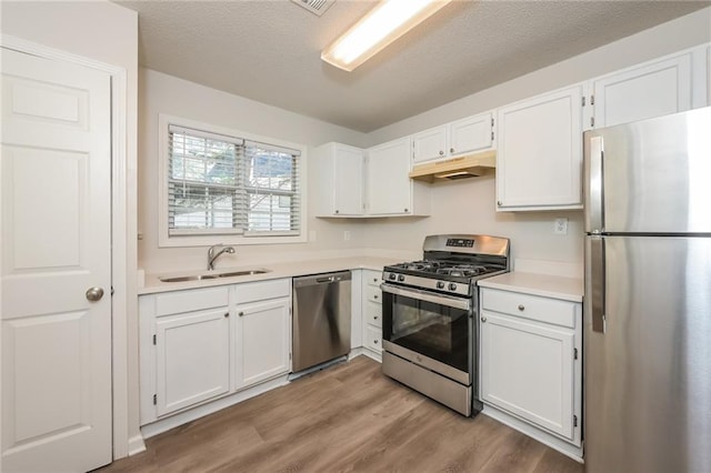 kitchen featuring light wood-type flooring, stainless steel appliances, white cabinetry, and sink