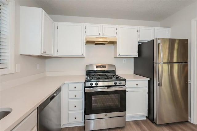 kitchen featuring white cabinets, stainless steel appliances, a textured ceiling, and light hardwood / wood-style floors