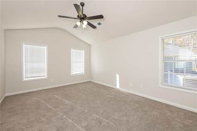 empty room with light carpet, a healthy amount of sunlight, and vaulted ceiling