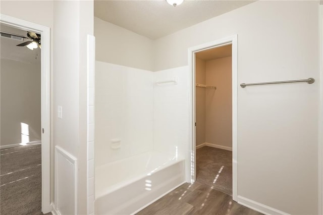 bathroom featuring shower / bathing tub combination, ceiling fan, and wood-type flooring