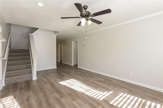 unfurnished living room featuring hardwood / wood-style flooring, ceiling fan, ornamental molding, and a textured ceiling