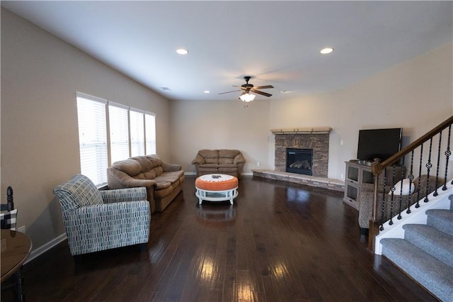 living room with dark hardwood / wood-style flooring, a fireplace, and ceiling fan