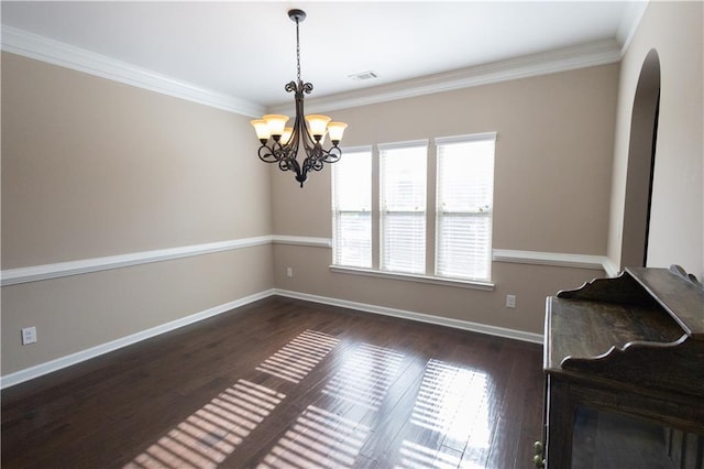 unfurnished dining area featuring an inviting chandelier, crown molding, and dark hardwood / wood-style floors