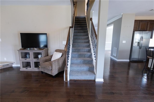 stairway with ornamental molding and wood-type flooring