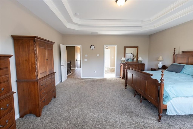 bedroom featuring a raised ceiling, crown molding, and light carpet