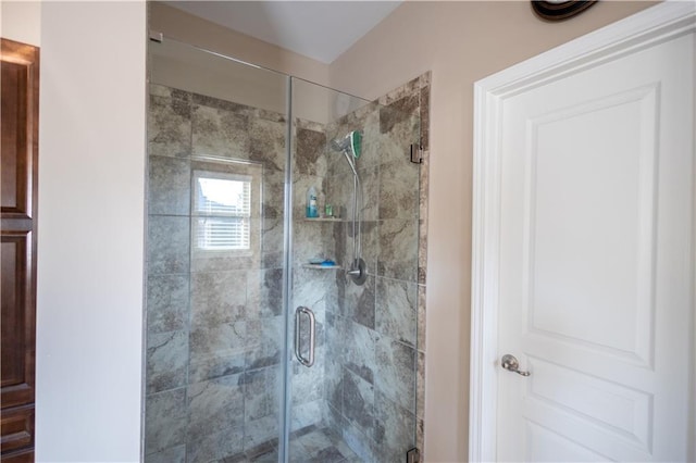 bathroom with a shower with door