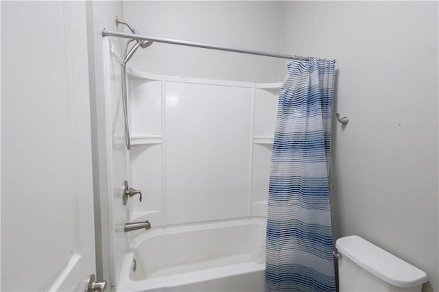 bathroom with shower / bathtub combination with curtain and toilet