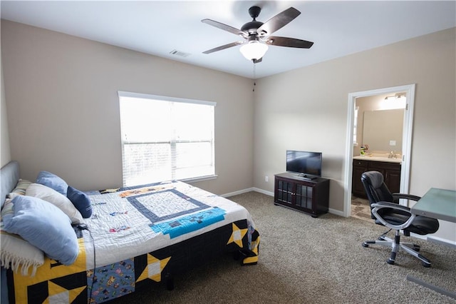 bedroom with ceiling fan, ensuite bathroom, carpet floors, and sink