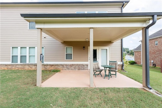 back of house featuring a patio area and a lawn