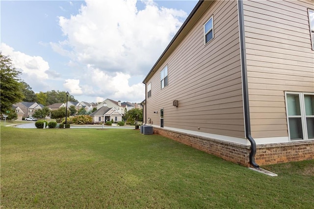 view of side of property with a lawn and central air condition unit