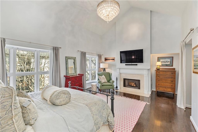 3475 Oak Valley Rd Unit 130, Atlanta, GA 30326 - bedroom featuring a fireplace with flush hearth, dark wood-style flooring, baseboards, an inviting chandelier, and high vaulted ceiling