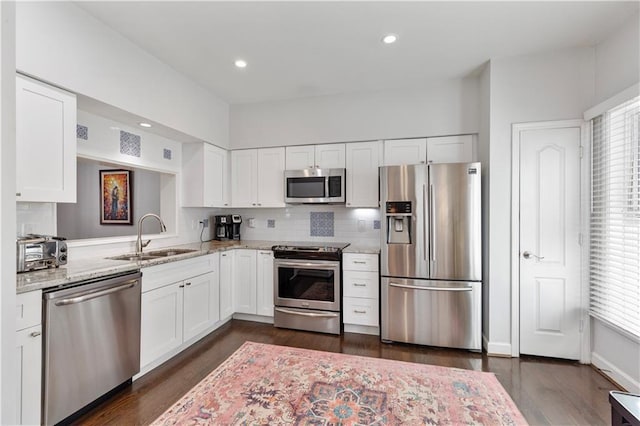 3475 Oak Valley Rd Unit 130, Atlanta, GA 30326 - kitchen with a sink, white cabinetry, backsplash, light stone counters, and appliances with stainless steel finishes