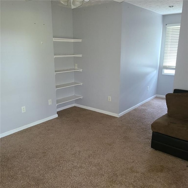 spare room featuring a textured ceiling and carpet floors