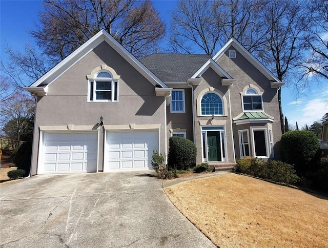 traditional home featuring driveway, a garage, and stucco siding