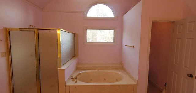 bathroom featuring vaulted ceiling, a shower stall, and a tub with jets