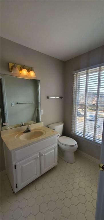 bathroom with toilet, lofted ceiling, and vanity