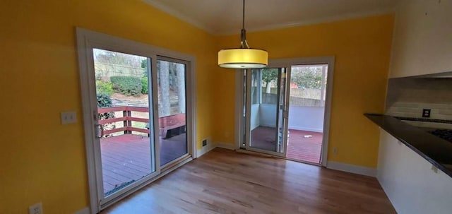 doorway featuring visible vents, baseboards, and wood finished floors