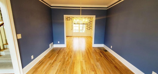 unfurnished dining area with ornamental molding, wood finished floors, and baseboards