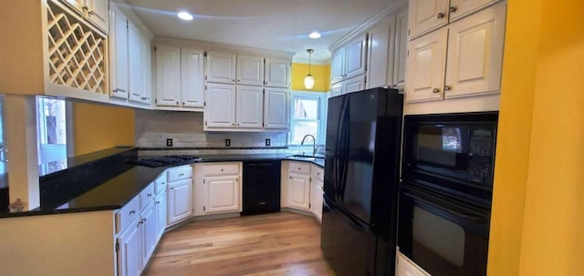 kitchen featuring dark countertops, white cabinetry, and black appliances