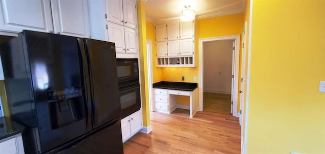 kitchen with baseboards, white cabinets, light wood-style flooring, and black appliances