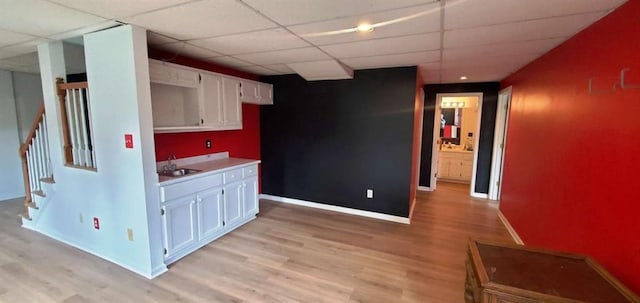 kitchen featuring light wood-type flooring, a sink, and white cabinetry