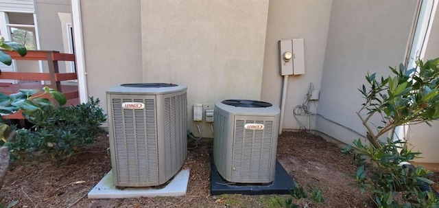 exterior details with electric meter, central AC unit, and stucco siding