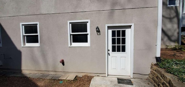 entrance to property featuring stucco siding