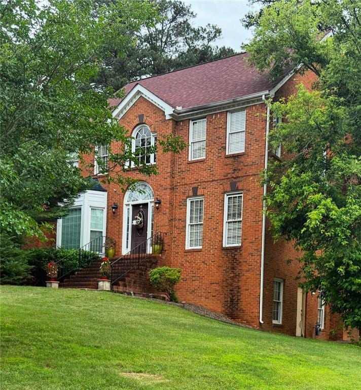 6868 Wynbrooke Cv, Stone Mountain, GA 30087 - colonial inspired home with a front yard, brick siding, and a shingled roof