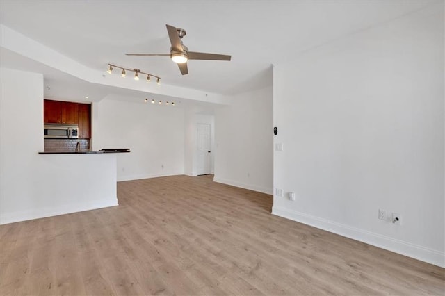 1075 Peachtree Walk NE Unit A421, Atlanta, GA 30309 - unfurnished living room with ceiling fan, light wood-style floors, and baseboards