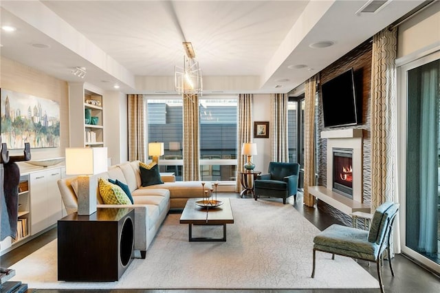 living room with a raised ceiling, a large fireplace, and concrete floors