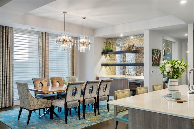 dining room featuring wine cooler, a chandelier, and dark wood-type flooring