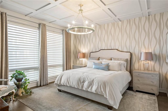 bedroom featuring beam ceiling, a chandelier, wood-type flooring, and coffered ceiling