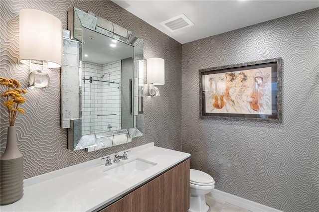 bathroom featuring vanity, toilet, and tiled shower