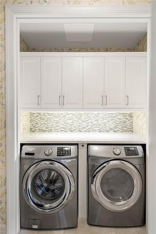 laundry area with cabinets and washing machine and clothes dryer