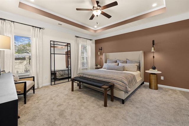 carpeted bedroom featuring multiple windows, ornamental molding, and a raised ceiling